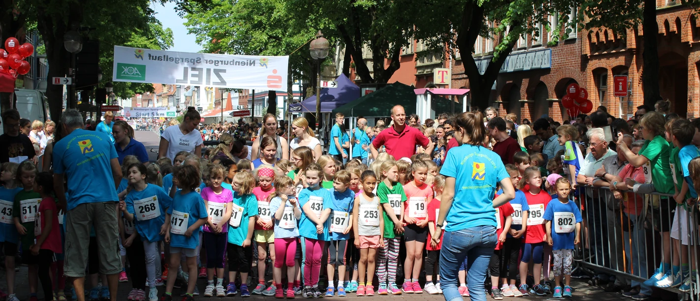 Nienburger Spargellauf A group of children stand expectantly at the start of the Nienburg asparagus run, surrounded by spectators.