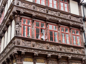 Eine Gästeführerin schaut aus dem Eickeschen Haus heraus.