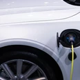 beispiel-e-mobilitaet_pexels-rathaphon-nanthapreecha.JPG Nahaufnahme eines weißen Elektroautos mit angeschlossenem Ladekabel an der Ladebuchse.