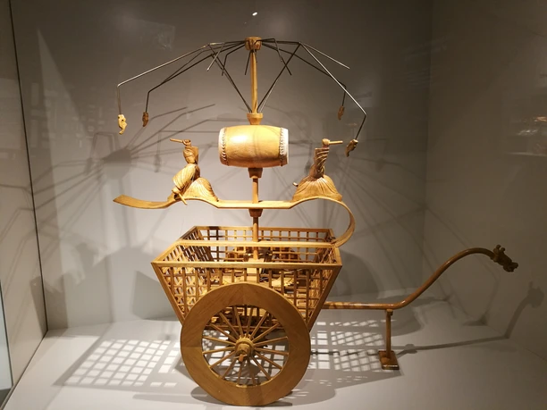 goldfarbener Wagen Holzmodell eines antiken Streitwagens mit filigranen Details und kunstvoll geschnitzten Rädern.