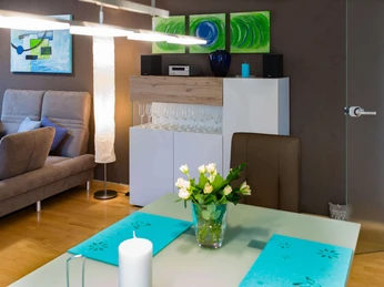 fewo-startpunkt1-essbereich1.jpg Ein stilvoller Essbereich mit modernem Design, Akzentbeleuchtung und kunstvoller Wanddekoration.