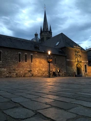 Domschatzkammer Außenansicht Dämmerung Außenansicht der Domschatzkammer im Dämmerlicht mit historischem Mauerwerk, beleuchtet von einem Straßenlaternenlicht, im Hintergrund erhebt sich ein Kirchturm