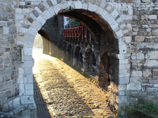 Historisches Stadttor, durch dessen mittelalterliches Gemäuer die Morgensonne hindurch scheint.