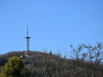 Aussichtsturm Hohe Hardt <p>Ein Sendeturm auf einem bewaldeten Hügel unter klarem blauem Himmel, umgeben von kahlen Bäumen.</p>