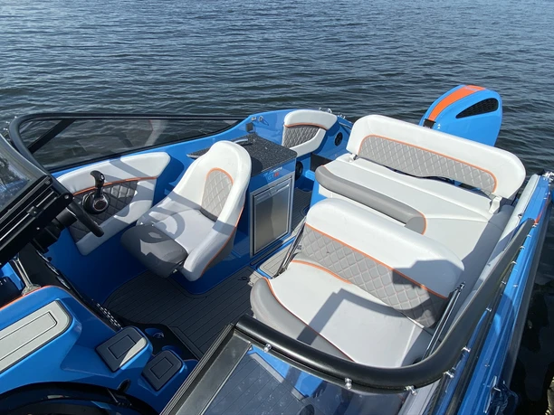 Sport und Eventboot Modernes Sport- und Eventboot mit blau-weißer Ausstattung auf einem ruhigen Gewässer.