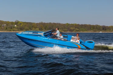 Sport und Eventboot seaQ Ein blaues Motorboot mit dem Namen "seaQ" navigiert mit mehreren Personen schnell über ein Gewässer.