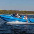 Sport und Eventboot seaQ Ein blaues Motorboot mit dem Namen "seaQ" navigiert mit mehreren Personen schnell über ein Gewässer.