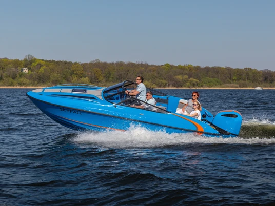 Sport und Eventboot seaQ Ein blaues Motorboot mit dem Namen "seaQ" navigiert mit mehreren Personen schnell über ein Gewässer.
