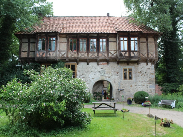 Vakwerkgebouw van het landhuis Brokeloh met historische charme, omgeven door een groene tuin.