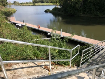 Der Hafen Stolzenau bietet einen modernen Steg mit Zugang über Treppen und ist von grüner Natur umgeben.