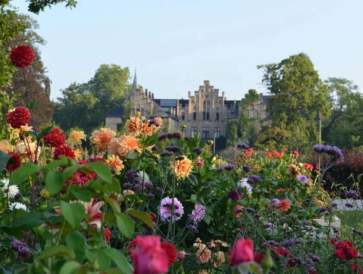 Schloss Ippenburg Tuin met rozen bij het Kasteel Ippenburg in Bad Essen in het Osnabrücker LandHistorisches Schloss im Hintergrund, Vordergrund mit bunten Blumen im Park.Historic castle in the background, foreground with colorful flowers in the park.Historisk slot i baggrunden, forgrund med farverige blomster i parken.
