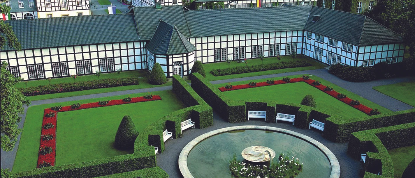 Luftaufnahme des Gräflichen Park mit symmetrischen Beeten, Hecken und einem eleganten Springbrunnen.