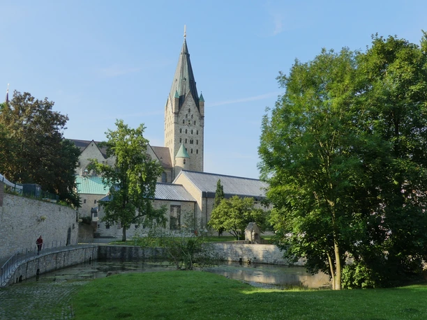Der imposante Turm der Kaiserpfalz erhebt sich majestätisch über eine grüne Parklandschaft.