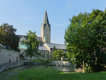 Dom und Kaiserpfalz Der imposante Turm der Kaiserpfalz erhebt sich majestätisch über eine grüne Parklandschaft.