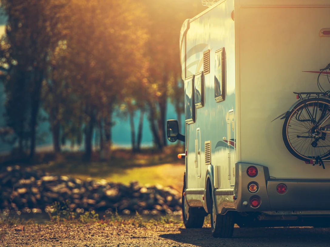 Autumn RV Camping. Modern Camper Van During Late Sunny Fall Afternoon. Scenic RV Park.