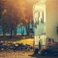 Autumn RV Camping. Modern Camper Van During Late Sunny Fall Afternoon. Scenic RV Park.