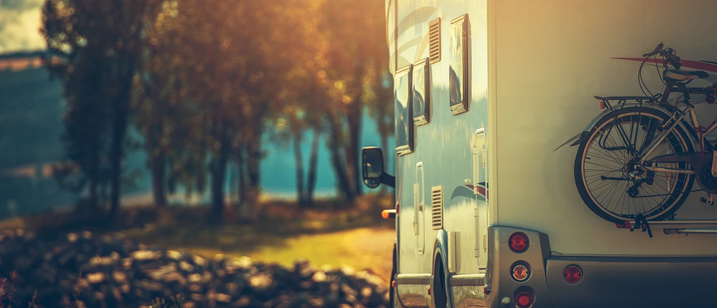 Autumn RV Camping. Modern Camper Van During Late Sunny Fall Afternoon. Scenic RV Park.