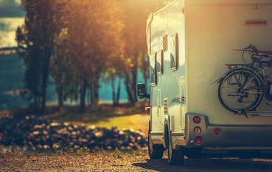AdobeStock_Camping 3.jpeg Autumn RV Camping. Modern Camper Van During Late Sunny Fall Afternoon. Scenic RV Park.