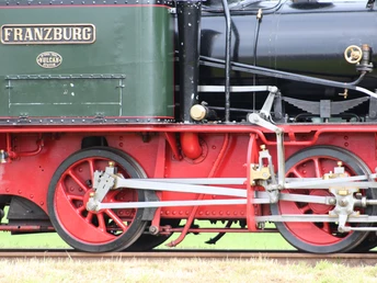 Historische Dampflokomotive mit detailreicher Mechanik und roten Rädern auf Gleis in Bruchhausen-Vilsen.