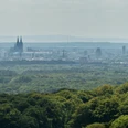 Odenthal Aussicht auf Kölns Skyline mit Dom und Fernsehturm im Hintergrund, Wälder im Vordergrund.