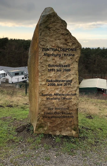 Steinmarker erinnert an die Geschichte der Zentraldeponie Nienburg/Krähe mit Betriebs- und Rekultivierungsdaten.