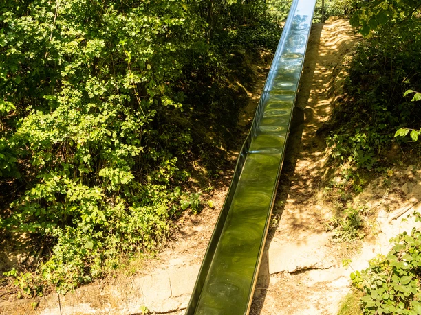 Das Bergische-Fatima Kapelle Grillhütte-2020-218 (13).jpg Rutsche im Wald, umgeben von üppiger Vegetation, lädt zu einem spannenden Abenteuer ein.