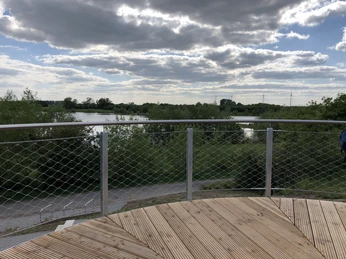 Aussichtsplattform Leese Eine hölzerne Aussichtsplattform mit Metallgeländer ermöglicht weiten Blick über grüne Landschaft und Gewässer.