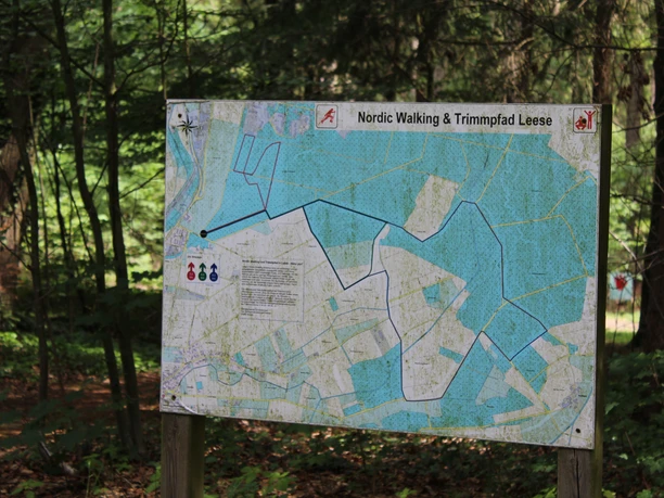 Bord in een bos toont de route van de nordic walking- en fitnessroute in Leese met startpunten.