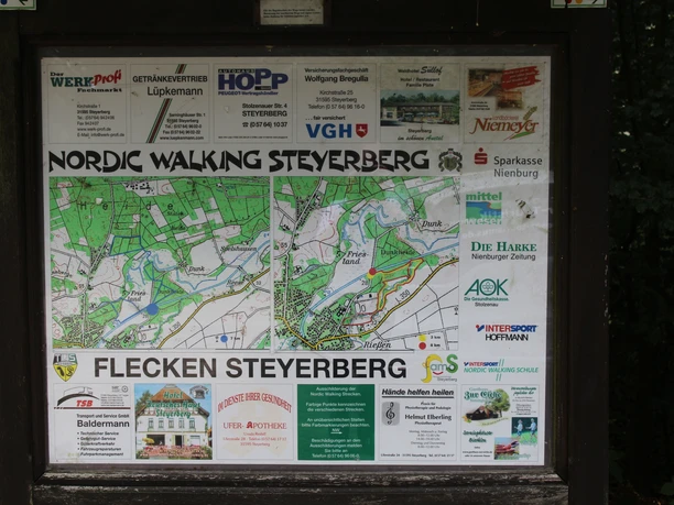 Nordic Walking informatiebord met kaart en advertenties in de buurt van Steyerberg op het platteland.