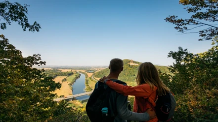 Ausblick Porta Kanzel Zwei Personen bestaunen den weiten Ausblick der bewaldeten Porta Kanzel über das Wesertal.