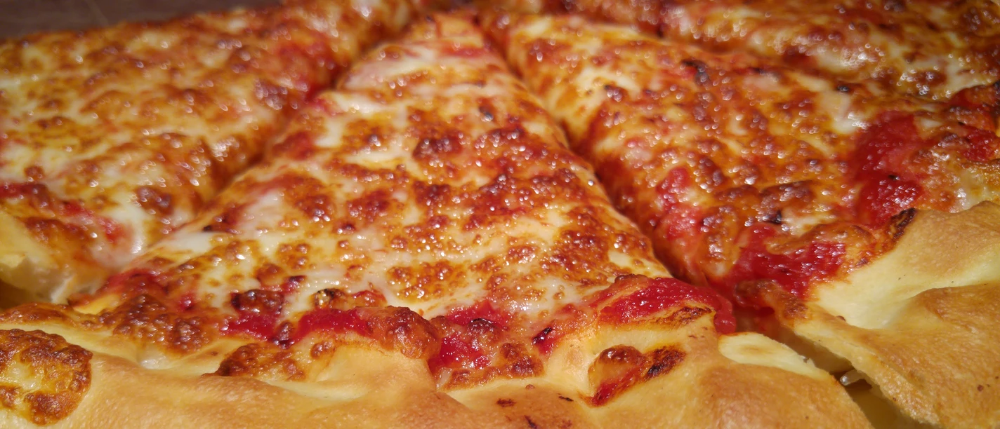 A perfect, golden-brown baked pizza with melted cheese and juicy tomato topping.