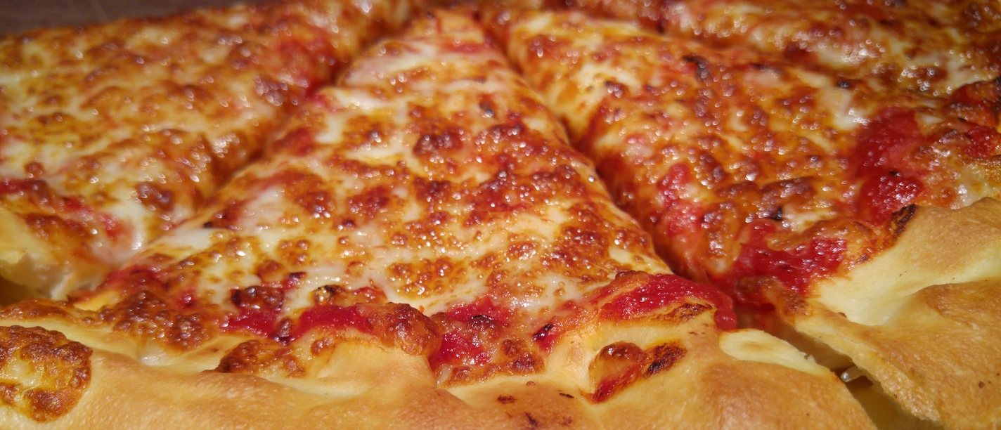 A perfect, golden-brown baked pizza with melted cheese and juicy tomato topping.