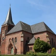 Thedinghausen Kirche Lunsen Alte Backsteinkirche mit markantem Turm in ländlicher Umgebung, blauer Himmel im Hintergrund.