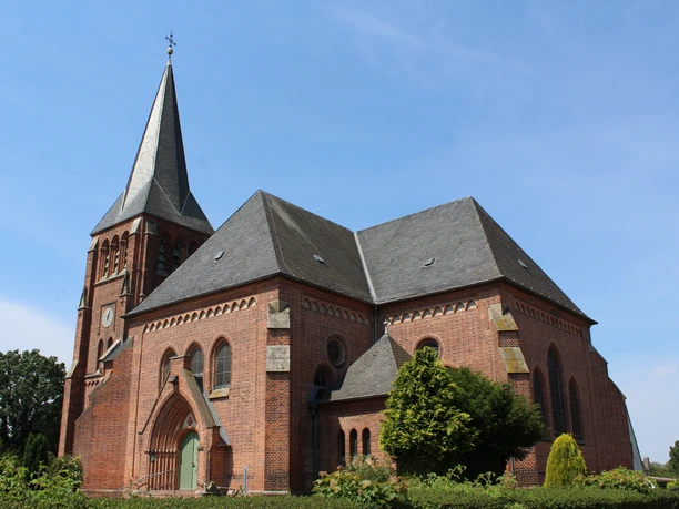 Thedinghausen Kirche Lunsen Alte Backsteinkirche mit markantem Turm in ländlicher Umgebung, blauer Himmel im Hintergrund.