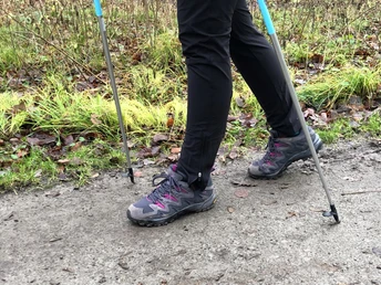 Nordic Walking Zwei Beine in Wanderstiefeln und Nordic-Walking-Stöcke auf einem Waldweg voller Herbstlaub.Two legs in hiking boots and Nordic walking poles on a forest path full of fall leaves.To ben i vandrestøvler og stavgangsstokke på en skovsti fuld af efterårsblade.Twee benen in wandelschoenen en nordic walking stokken op een bospad vol herfstbladeren.