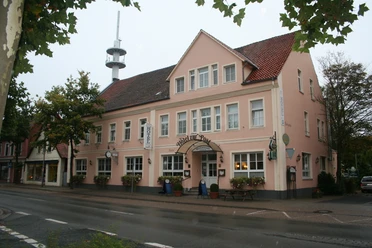 Hotel Zur Post Ein rosafarbenes Gebäude mit traditioneller Fassade und mehreren Fenstern auf zwei Etagen.