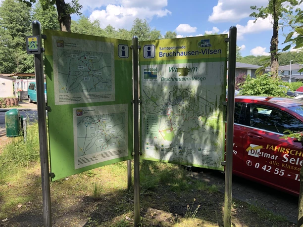 Op de foto zie je een overzichtsbord met wandelroutes in Bruchhausen-Vilsen bij zonnig weer.