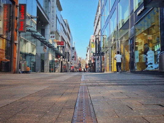 Hohe Straße Die Hohe Straße in Köln zeigt eine belebte Einkaufsstraße mit modernen Glasfassaden und Menschen.Hohe Strasse in Cologne is a busy shopping street with modern glass facades and people.