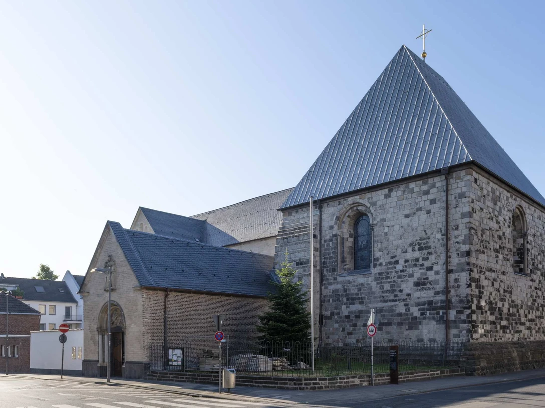 St. George Romanische Kirche St. Georg mit Natursteinfassade und steilem Satteldach bei Tageslicht.Romanesque church of St. George with natural stone façade and steep pitched roof in daylight.