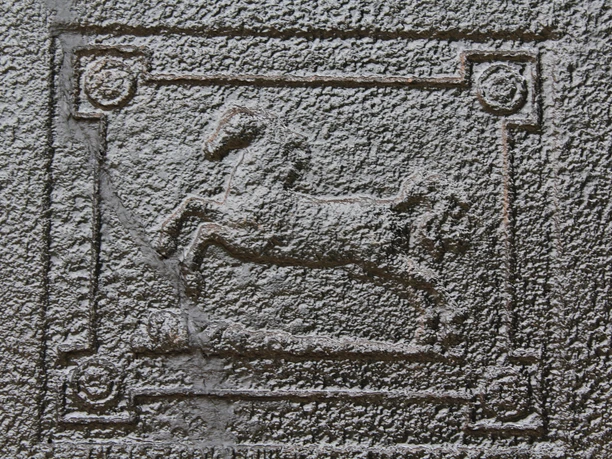 Reiterhof Wikner Basrelief eines galoppierenden Pferdes in einem rechteckigen Rahmen mit vier dekorativen Ecken.