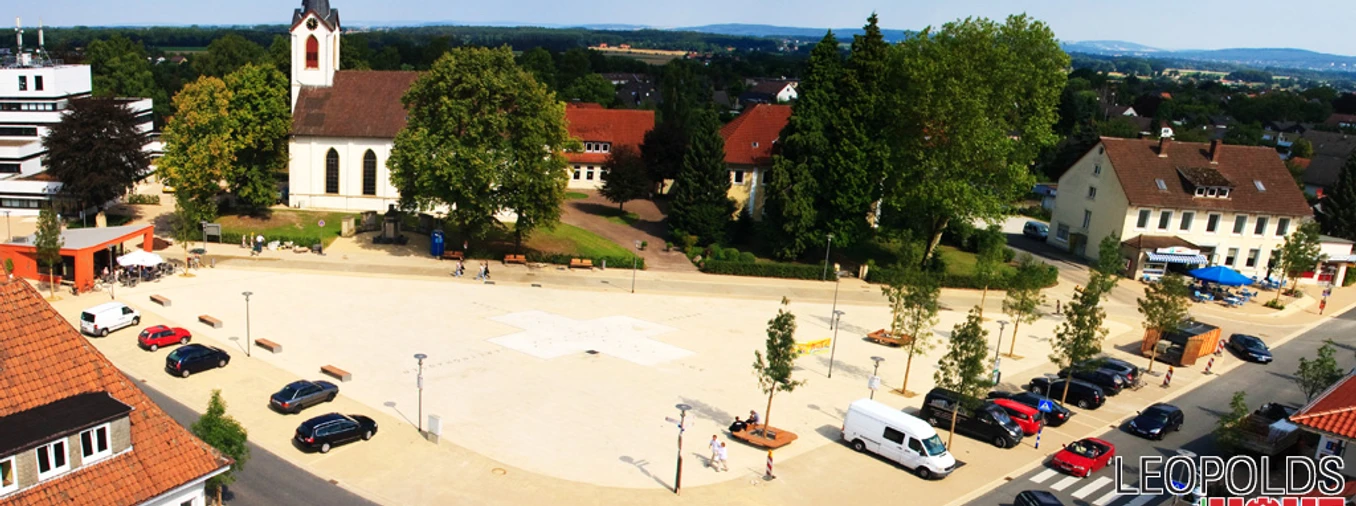 Marktplatz Leopoldshöhe Luftbild des weitläufigen Marktplatzes von Leopoldshöhe mit Kirche, Gebäuden und Autos.
