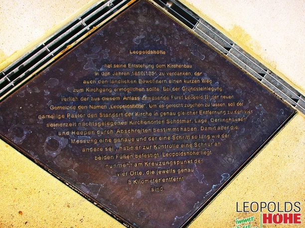 Marktplatz Leopoldshöhe Gedenktafel Gedenktafel aus Metall mit Inschrift über den historischen Kirchenbau auf dem Marktplatz Leopoldshöhe.