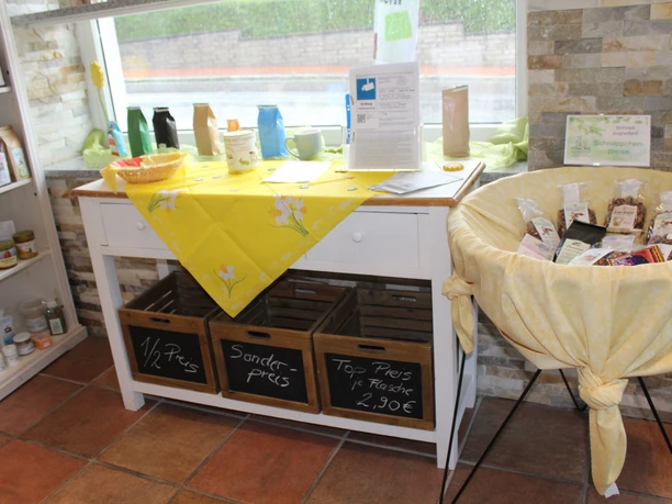 Tee-Shop Hiller Ein einladender, gut beleuchteter Verkaufsbereich, der verschiedene Teesorten und Produkte präsentiert.