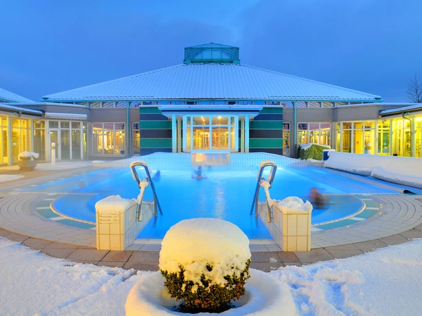 Driburger Therme im Winter Ein Spa-Becken der Driburger Therme ist umgeben von Schnee, unter einem beleuchteten Winterhimmel.
