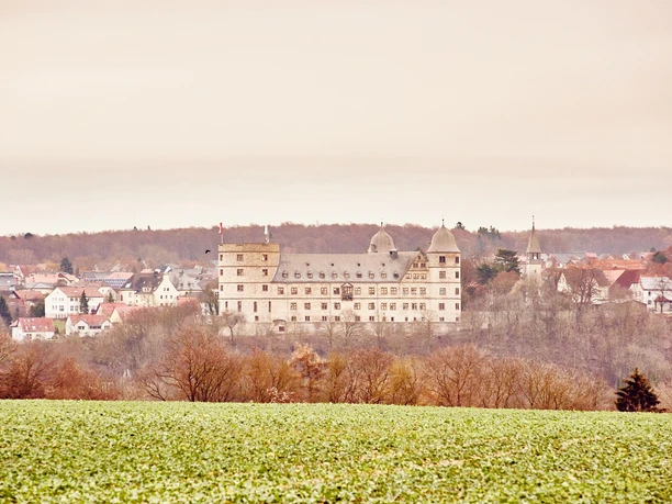 Die Jugendherberge Wewelsburg thront imposant auf einem Hügel, umgeben von grünen Feldern.