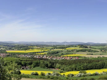Aussicht auf Bösingfeld von der Hohen Asch Blick über Bösingfeld: sanfte Hügel, grüne Felder und Windräder unter einem klaren Himmel.