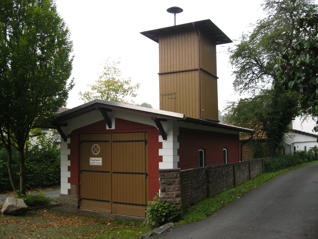 Altes Spritzenhaus in Extertal-Almena Historisches Feuerwehrhaus mit rotem Ziegelbau und Holzaufbau in Extertal-Almena, umgeben von Bäumen.