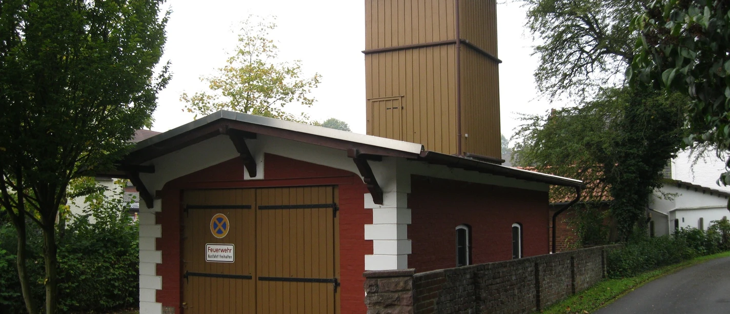 Altes Spritzenhaus in Extertal-Almena Historisches Feuerwehrhaus mit rotem Ziegelbau und Holzaufbau in Extertal-Almena, umgeben von Bäumen.