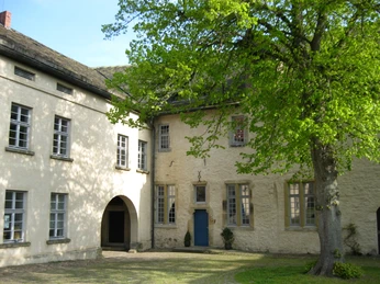 Burghof der Oberburg Burghof der Oberburg mit historischem Gebäude, umgeben von grünen Bäumen und einem gepflasterten Boden.