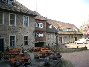 Innenhof der Unterburg mit Burgcafé Historische Burgmauern umgeben einen Innenhof mit vielen Sitzgelegenheiten vor einem Café.